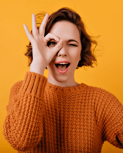 blissful-young-woman-with-pale-skin-making-funny-faces-during-photosoot