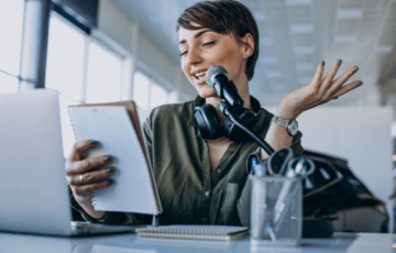 people-entertainment-hobby-concept-cheerful-young-african-american-woman-with-curly-hair-holds-modern-smartphone-listens-music-via-stereo-headphones-poses-against-vivid-orange-background