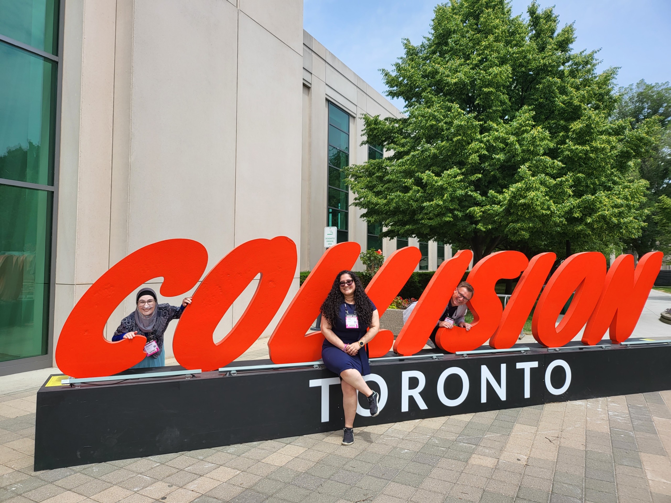 Some of the AdTonos team pose in front of a Collision Toronto sign