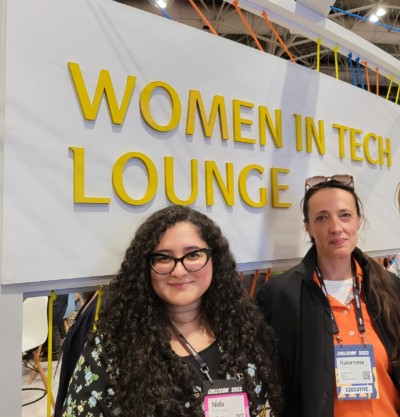 Adtonos' Nida El Amraoui and Kasia Bargielska stand in front of the Women in Tech Lounge sign
