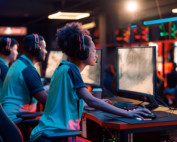 Team playing esports game on computer in internet club